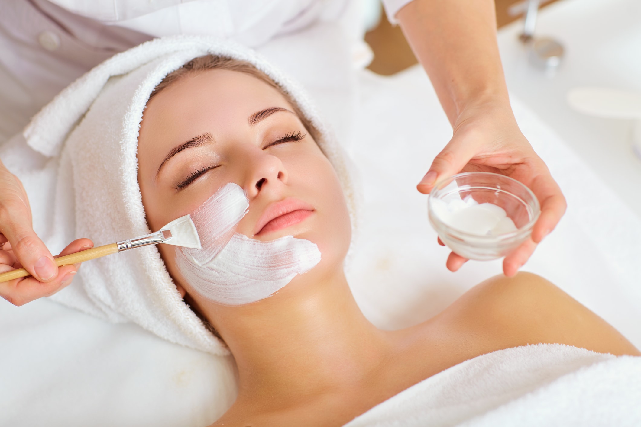Aesthetician performing a facial treatment at Turn Back Time Spa